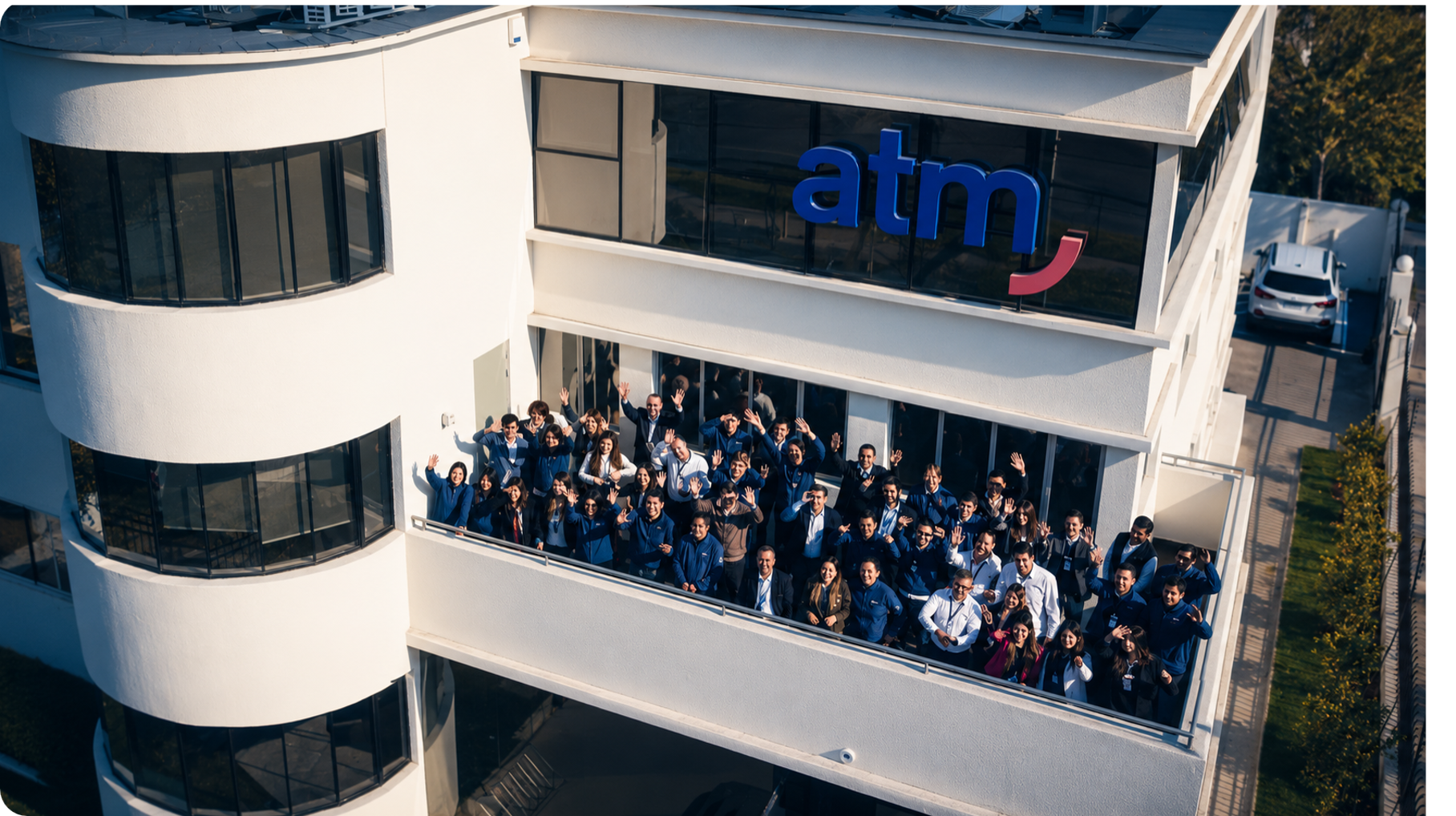 Edificio corporativo de ATM Alta Tecnología Médica con su equipo de colaboradores reunido en el balcón de las oficinas en Chile.